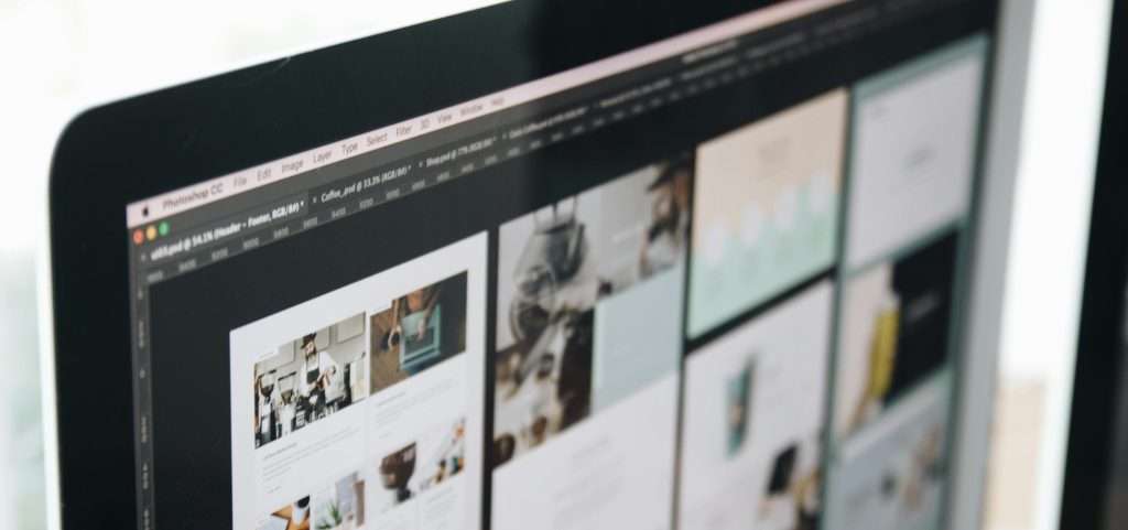 Close up of iMac from a diagonal angle. The screen has a range of web designs on display.