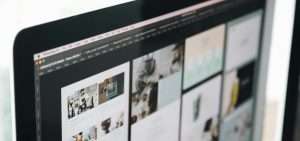 Close up of iMac from a diagonal angle. The screen has a range of web designs on display.